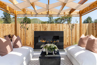 American Fyre Designs Milan Low 211-LO outdoor fireplace in official outdoor lifestyle setting; decorative media shown sold separately