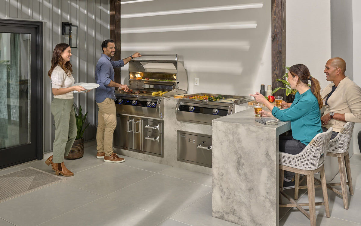 Fire Magic grill at the center of an outdoor kitchen gathering